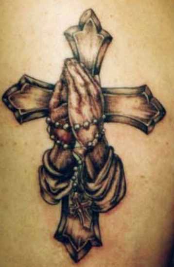 A tatuagem no ombro da menina - cruz e na palma da mão