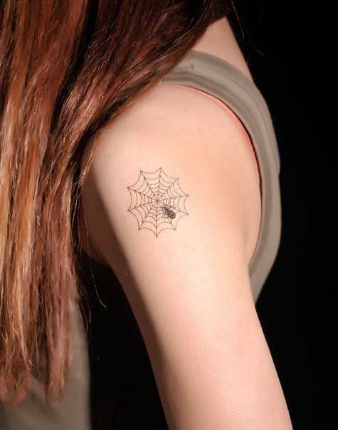 A tatuagem no ombro da menina - uma teia de aranha e a aranha