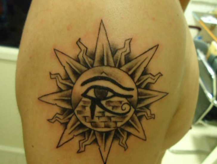 A tatuagem no ombro de um cara - a pirâmide com o olho e o sol