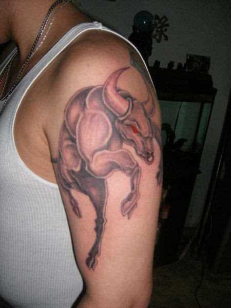 A tatuagem no ombro de um cara com a imagem de um touro pulando