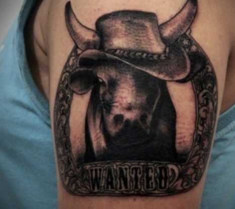 A tatuagem no ombro de um cara - de- boi no chapéu