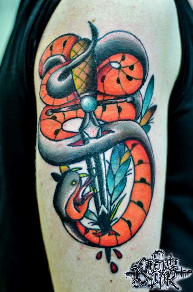 A tatuagem no ombro de um cara - de- cobra e o punhal