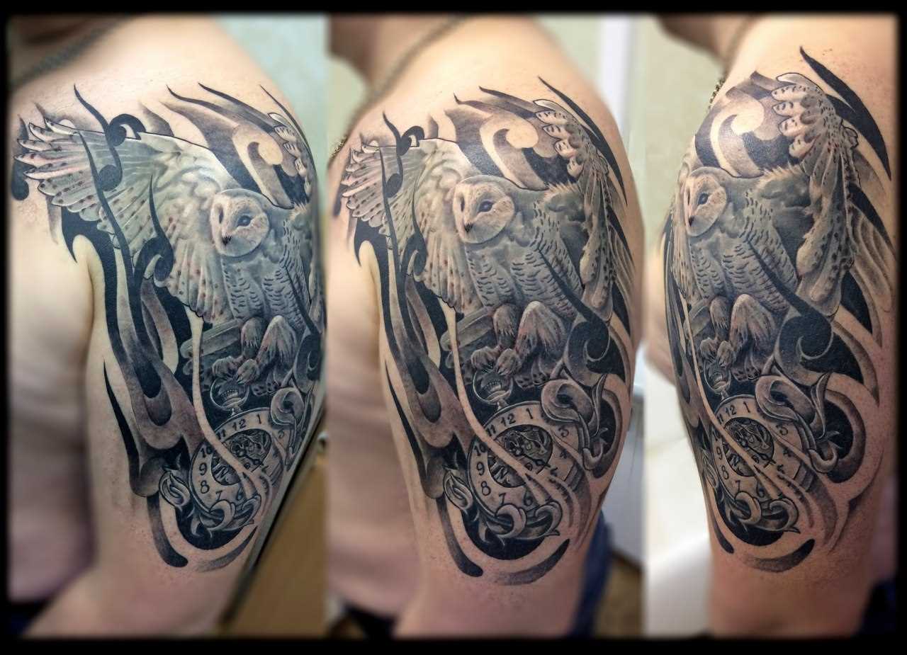 A tatuagem no ombro de um cara - de- coruja e relógios