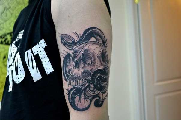 A tatuagem no ombro de um cara de crânio e a cobra