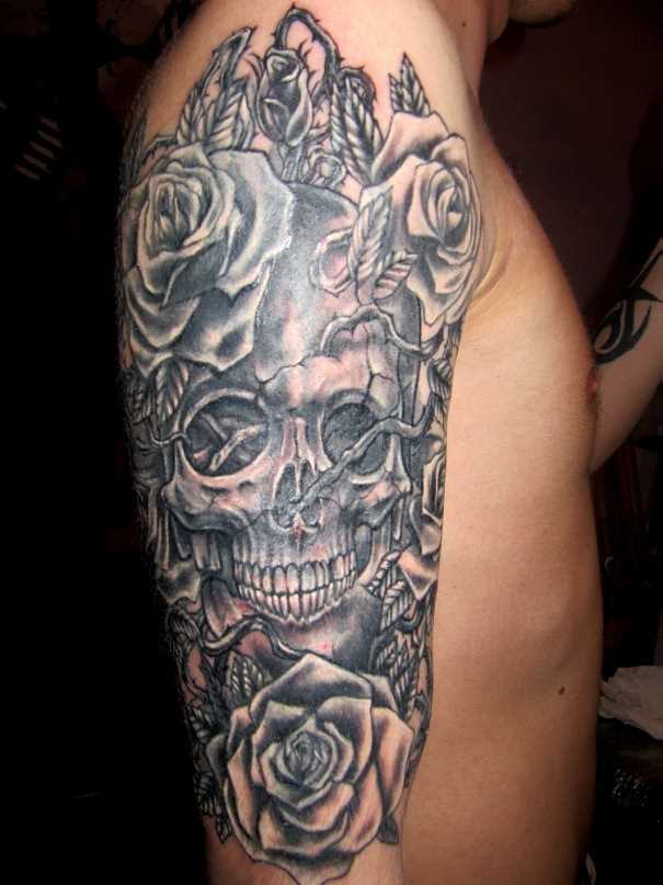 A tatuagem no ombro de um cara de crânio e rosas