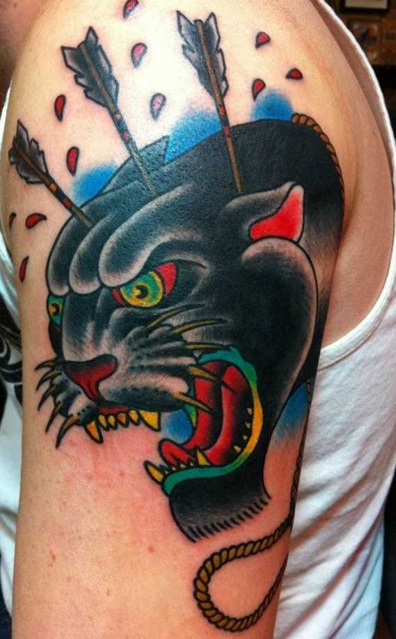 A tatuagem no ombro de um cara - de pantera com flechas na cabeça