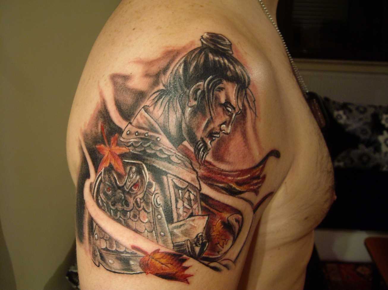 A tatuagem no ombro de um cara - de samurai e folhas