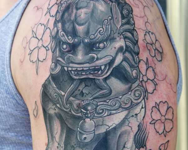 A tatuagem no ombro de um cara em forma de cão japonês