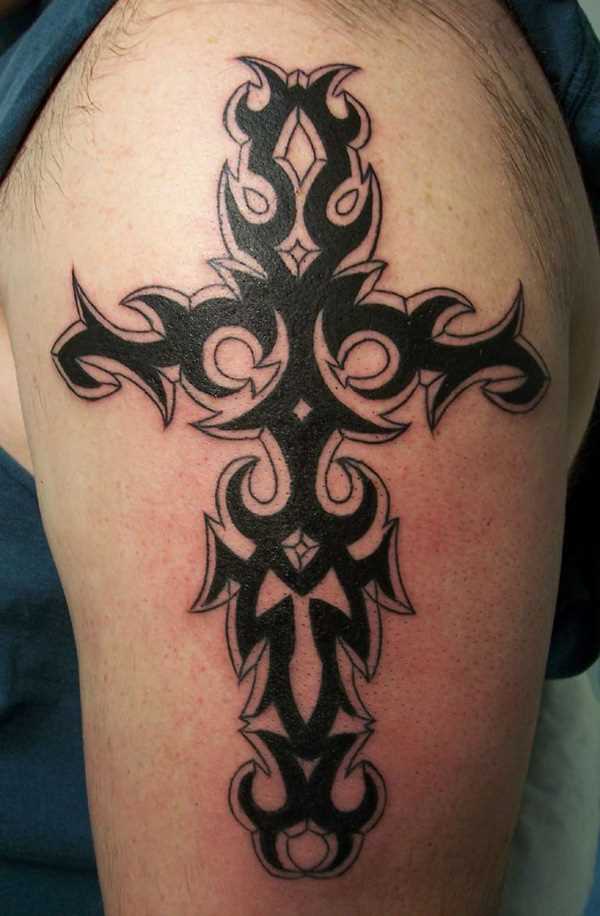 A tatuagem no ombro de um cara em forma de cruz