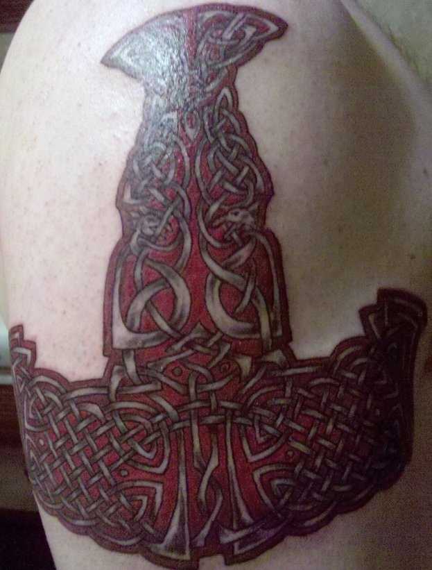 A tatuagem no ombro de um cara em forma de martelo com o celtic padrão