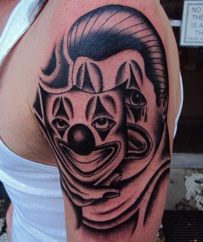A tatuagem no ombro de um cara em forma de máscara