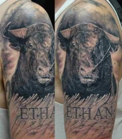 A tatuagem no ombro de um cara - o touro e a inscrição