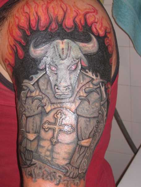 A tatuagem no ombro de um cara - o touro e o fogo