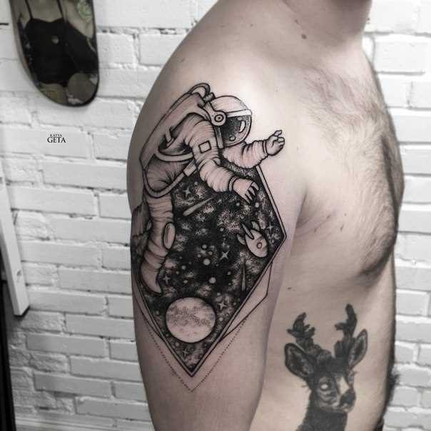 A tatuagem no ombro de um cara - um astronauta no espaço