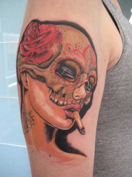 A tatuagem no ombro do cara no estilo chicano - retrato de uma menina