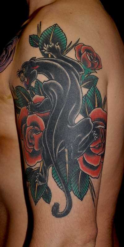 A tatuagem no ombro o homem - pantera e rosas