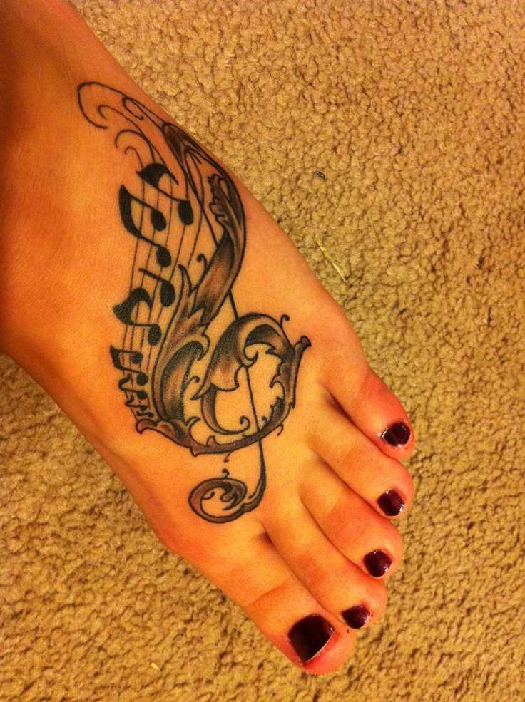 A tatuagem no pé da menina - clave de sol e notas