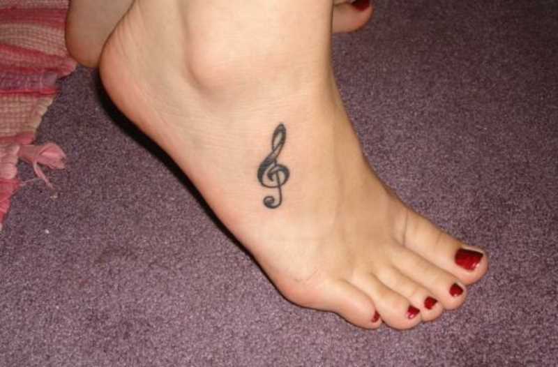 A tatuagem no pé da menina - clave de sol