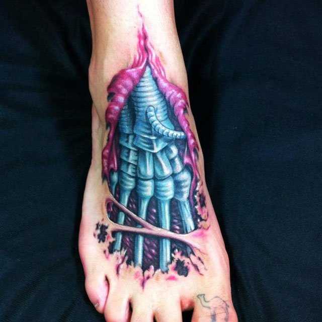 A tatuagem no pé da menina no estilo de biomecânica