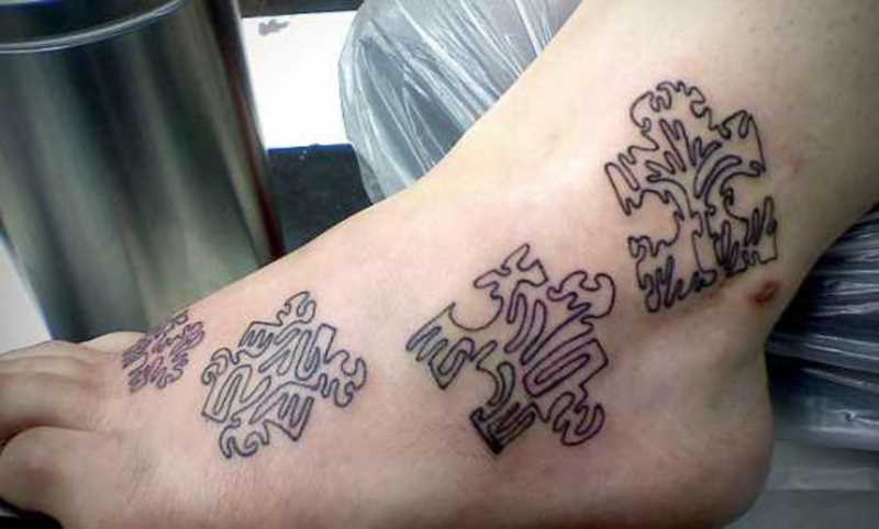 A tatuagem no pé de uma menina de quebra - cabeças