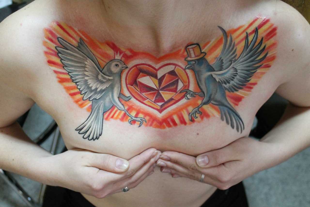 A tatuagem no peito da menina - pombos e coração