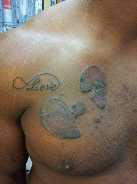 A tatuagem no peito de um cara de quebra - cabeça e inscrição