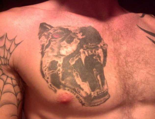 A tatuagem no peito de um cara em forma de cão