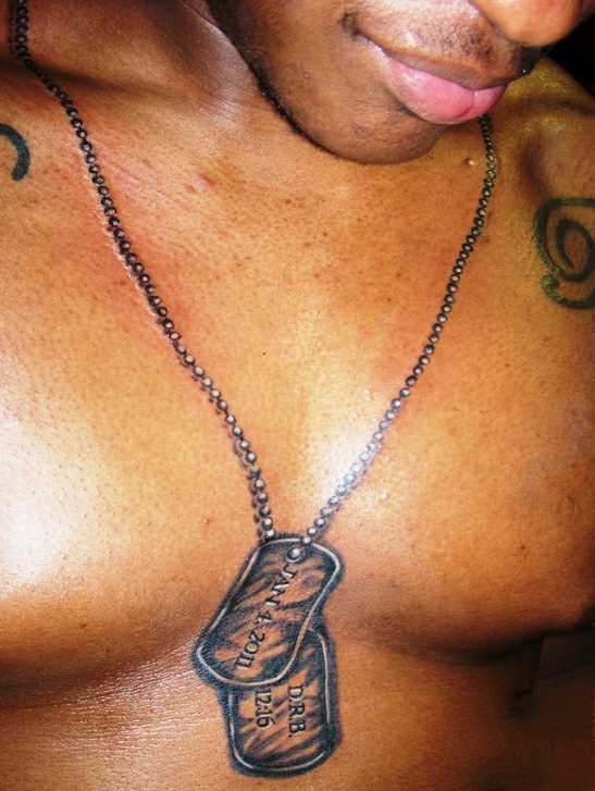 A tatuagem no peito do cara com corrente e pingentes militares