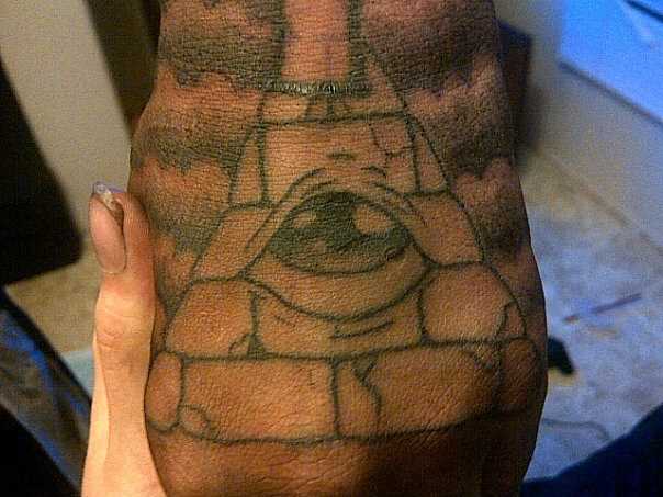 A tatuagem no pincel o cara - a pirâmide com o olho