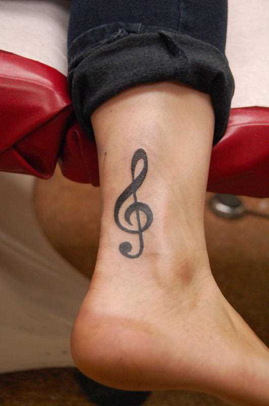 A tatuagem no tornozelo preto, as meninas - clave de sol