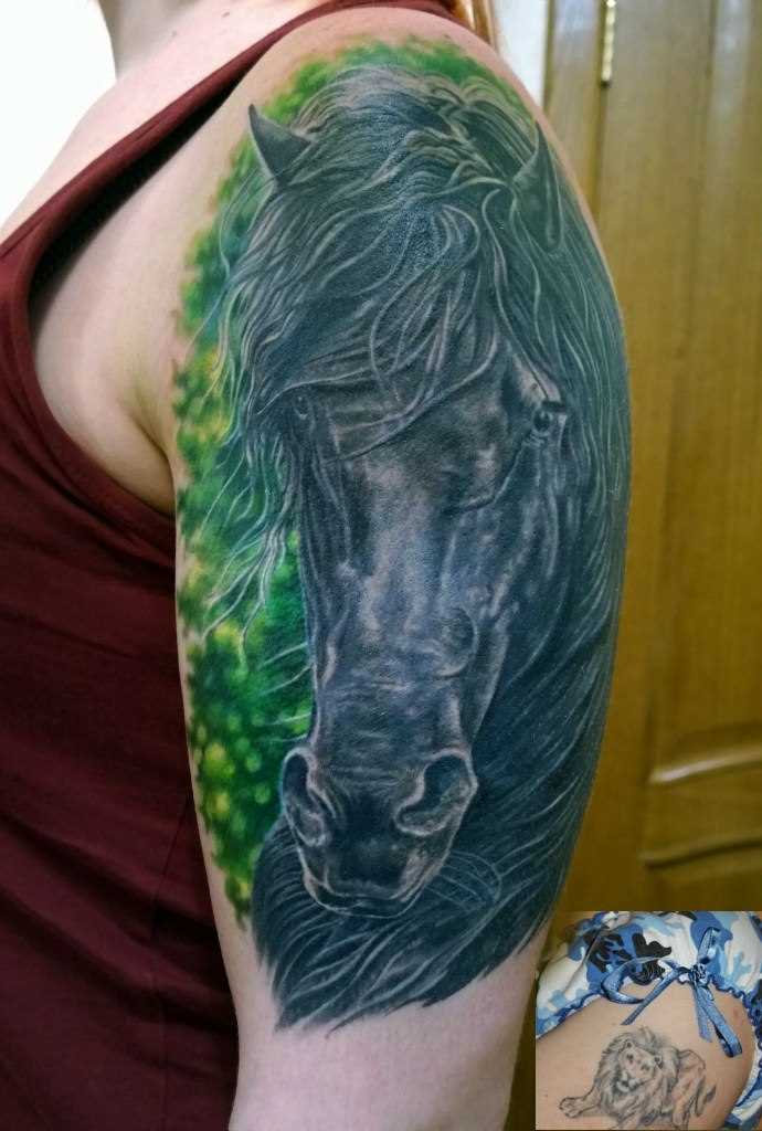 A tatuagem preto do cavalo no ombro de um cara