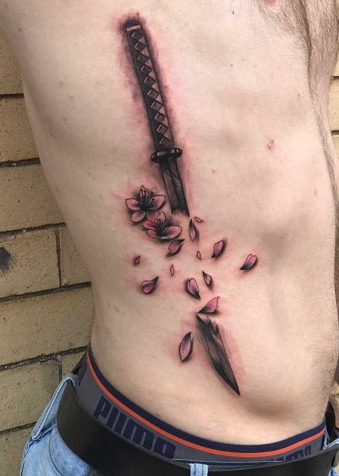 A tatuagem raskoloto espada ao lado de homens