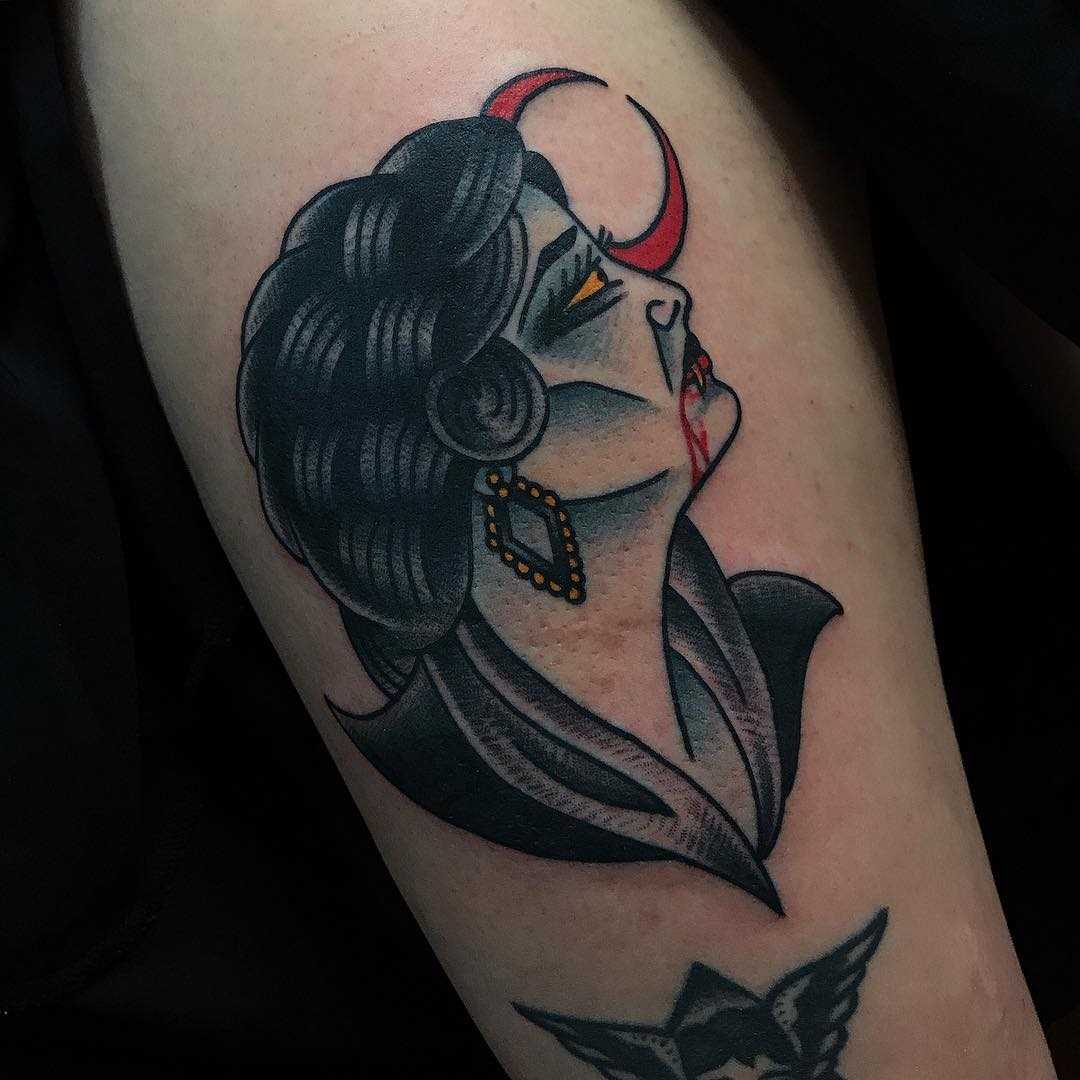 A tatuagem vampiro sobre a perna da mulher