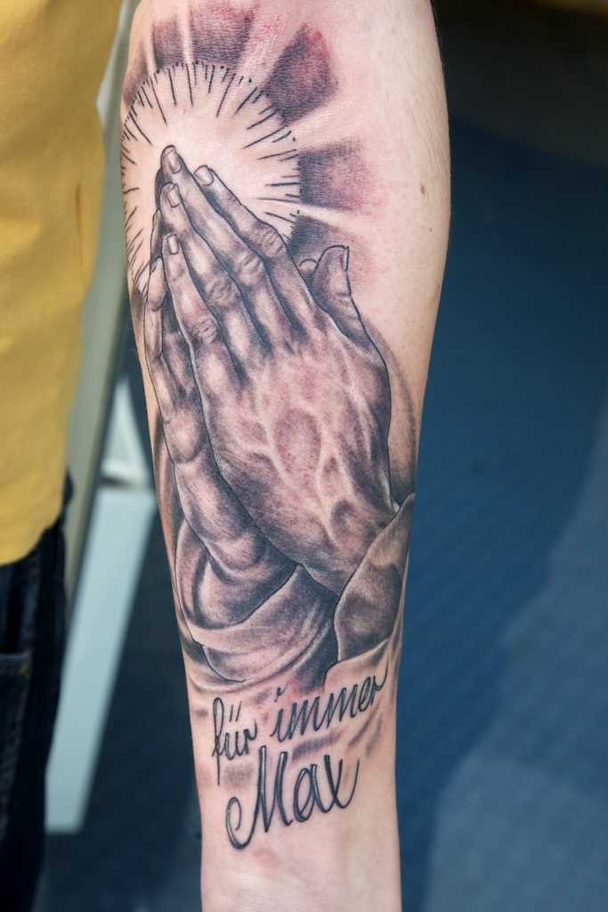 As mãos em oração tatuagem chicano no antebraço cara