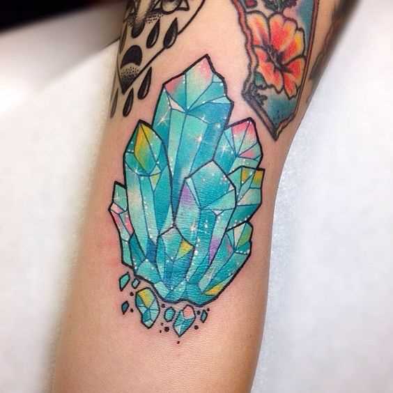 Azul tatuagem de cristal na mão da menina