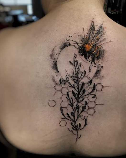 Bela tatuagem de uma abelha na coluna da menina