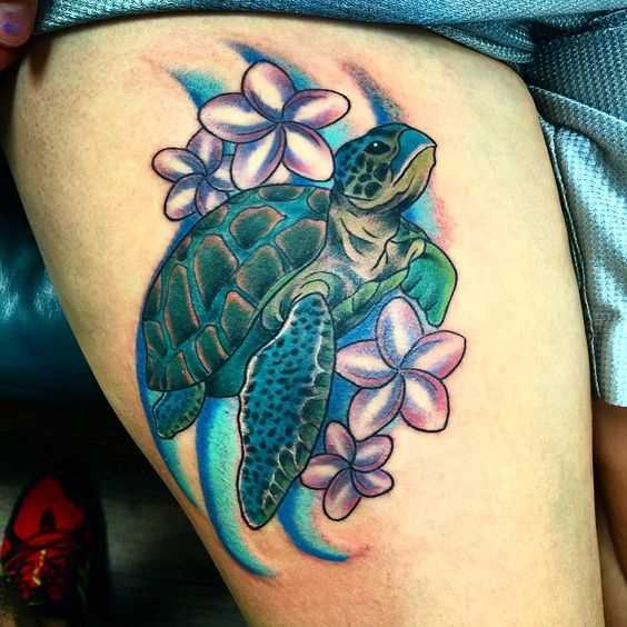 Bela tatuagem de uma tartaruga, com flores no quadril da menina