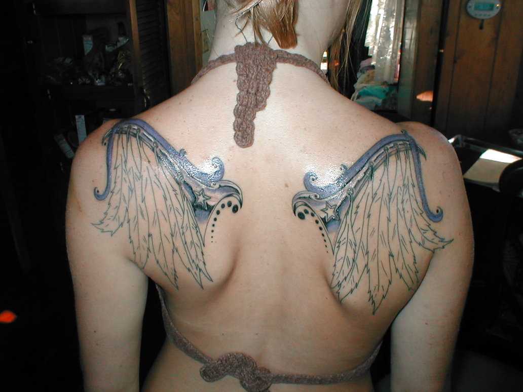 Bela tatuagem na parte de trás da menina - asas