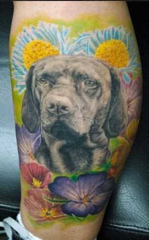 Bela tatuagem na perna da menina em forma de cão e cores