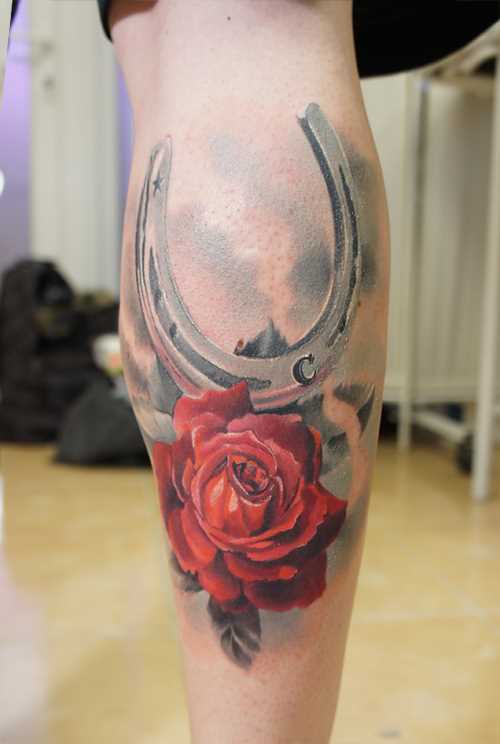 Bela tatuagem na perna da menina - ferradura e rosa