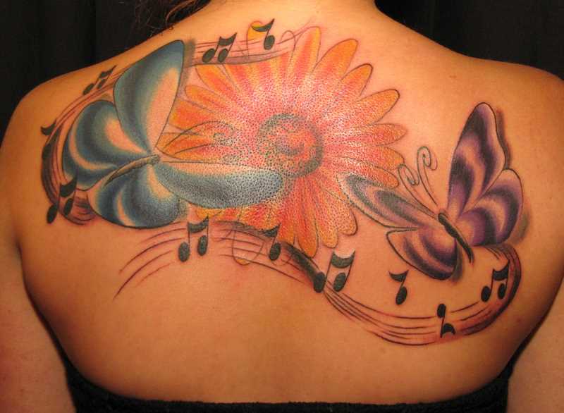Bela tatuagem nas costas de uma menina nota, a borboleta e a flor