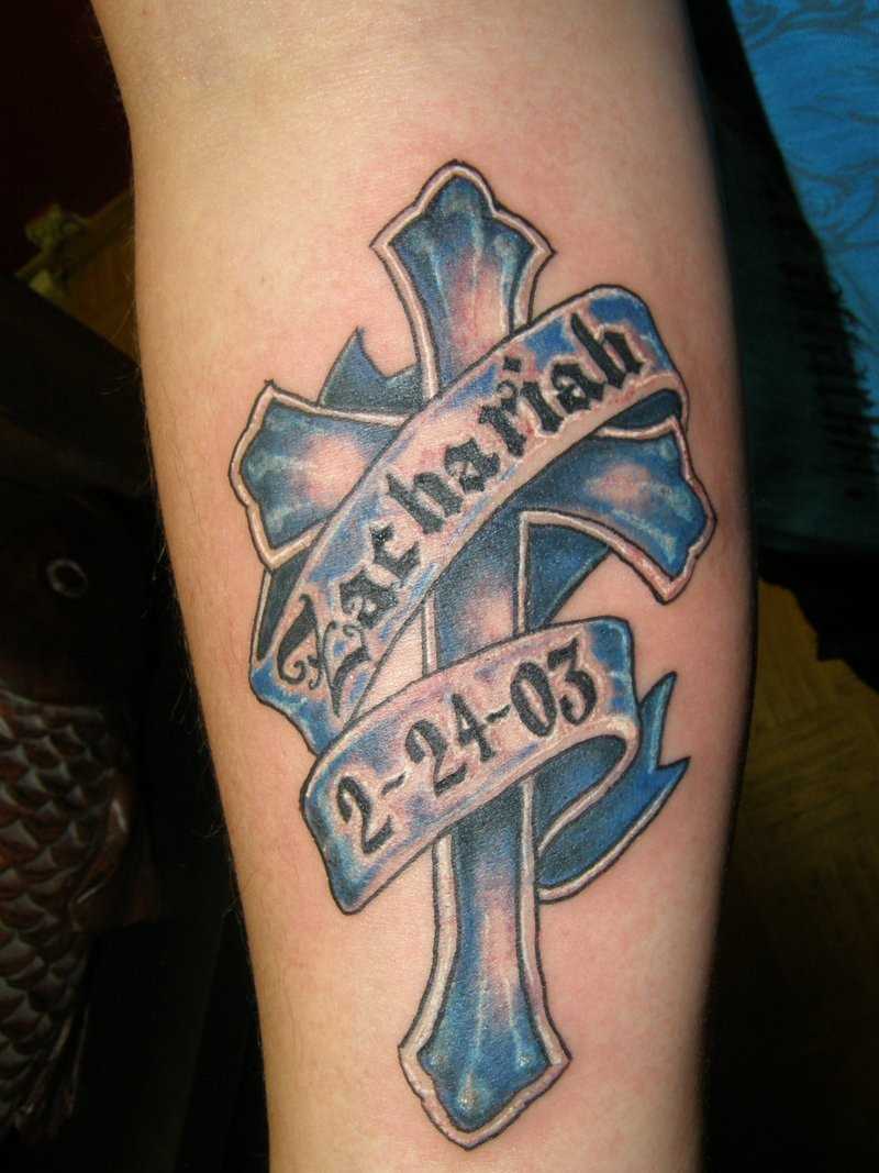 Bela tatuagem no antebraço da menina - a cruz e a inscrição