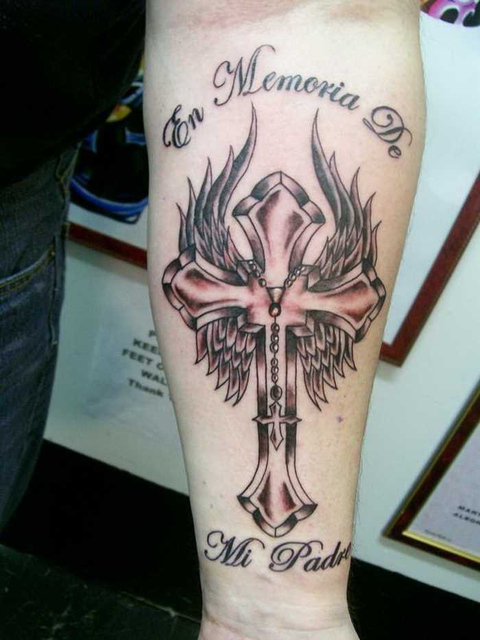 Bela tatuagem no antebraço meninas - cruz com asas e inscrição