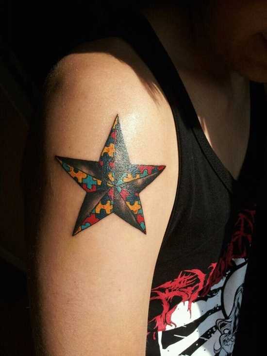 Bela tatuagem no ombro da menina - de quebra-cabeça em forma de estrela