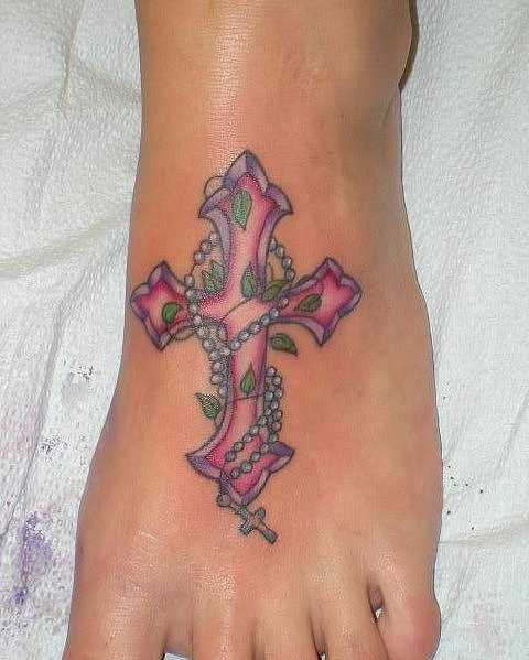 Bela tatuagem no pé da menina - um colar com uma cruz
