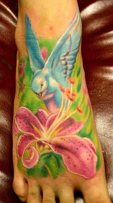 Bela tatuagem no pé de uma menina - o lírio e a pomba