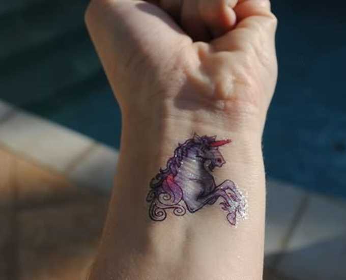 Bela tatuagem no pulso da menina - que é um unicórnio