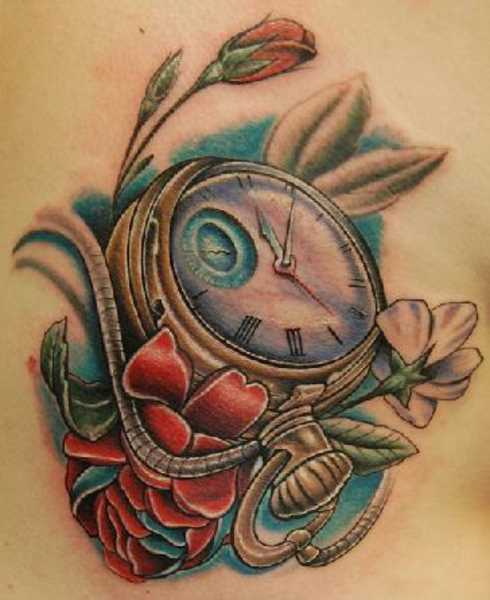 Bela tatuagem que a menina na região lombar - um relógio de bolso e flores