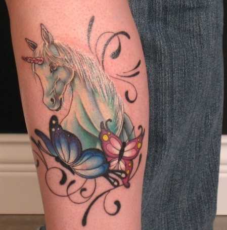 Bela tatuagem que a menina sobre a perna - de unicórnio e a borboleta