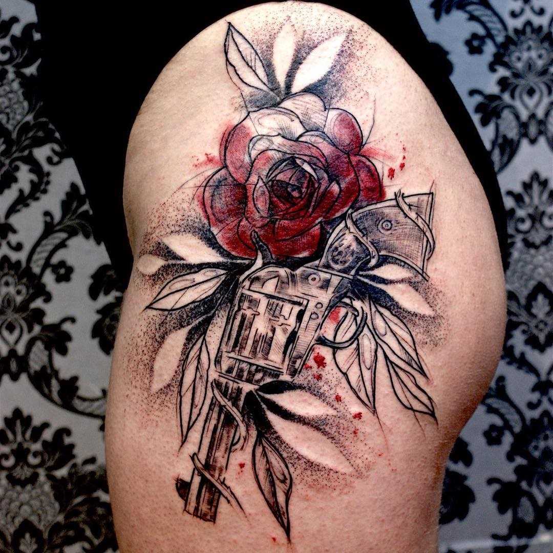 Bela tatuagem revólver com uma rosa na altura do quadril de uma mulher